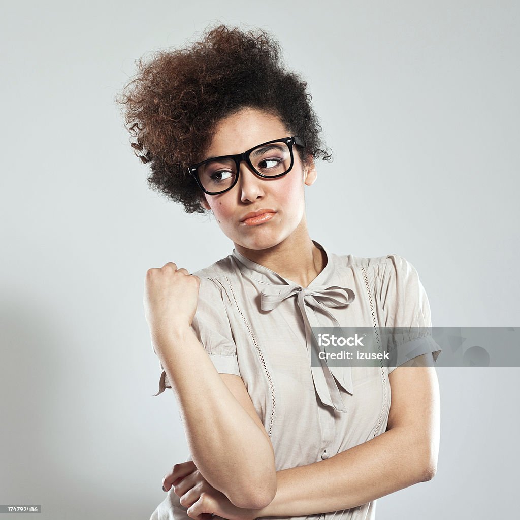 Disappoitment Portrait of teenaged afro girl wearing nerd glasses and looking away. Studio shot, grey background. 18-19 Years Stock Photo