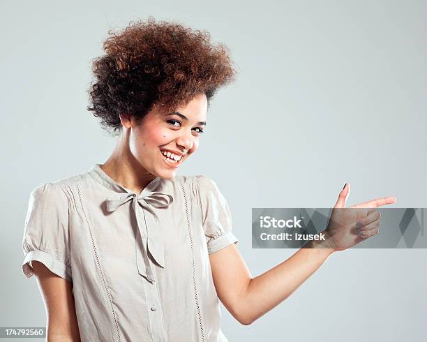 Cute Girl Pointing At Copy Space Stock Photo - Download Image Now - Gray Color, Pointing, Smiling