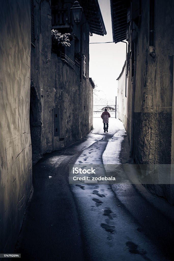 Lonely Man Walking in Alley while Snowing Lonely man in italian alley Senior Adult Stock Photo