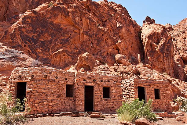 Historic Civilian Conservation Corps Cabins Valley of Fire is Nevada’s oldest state park. The park gets its name from the red rock formations which appear to be on fire as the sun sets. These Aztec sandstone rocks were formed from sand dunes 150 million years ago. The region was further shaped by uplifting and faulting followed by extensive erosion. The Anasazi people visited this area from about 300 BC to 1150 AD. Scarcity of water would have prevented their living here but they probably hunted, gathered food and performed religious ceremonies. There are several sites where their petroglyphs can still be seen. In 1931, 8,760 acres of federal land was transferred to the state of Nevada. In 1933, the Civilian Conservation Corps (CCC) began developing the park which opened in 1934. The CCC continued working on the park into the early 1940’s and built campgrounds, trails, visitor cabins, ramadas and roads. In 1935, the Nevada State Legislature designated the area as Valley of Fire State Park. In 1968, the park was recognized as a National Natural Landmark. This scene of the historic CCC cabins was photographed at Valley of Fire State Park which is located 50 miles northeast of Las Vegas near Overton, Nevada, USA. jeff goulden valley of fire state park stock pictures, royalty-free photos & images