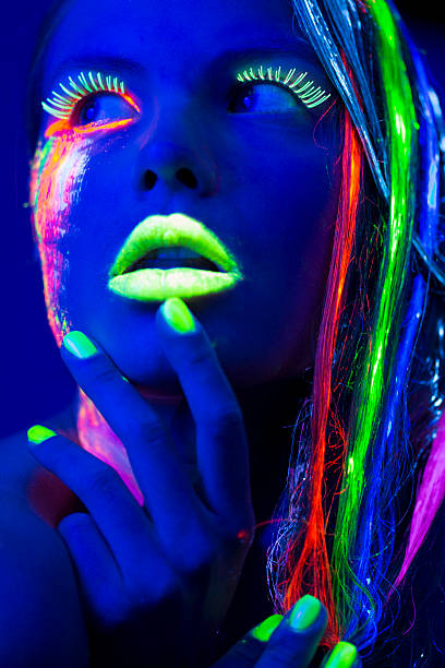 istock Women Portrait with Glowing Multi Colored makeup in black light 174793828