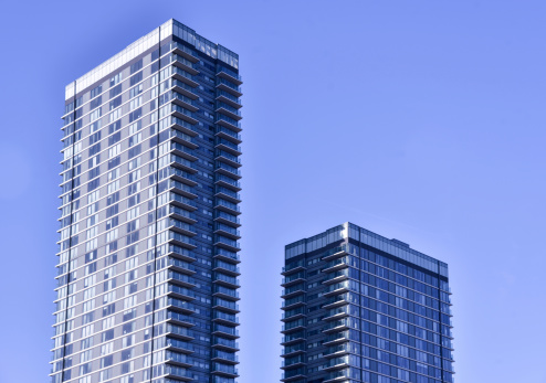 Two modern glass Apartment buildings and clear blue sky