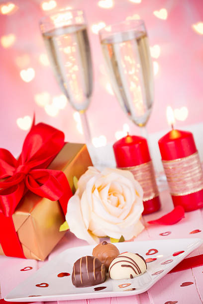 Valentines day greeting card with romantic red roses, champagne bottle on white. Top view with space for text. Flat lay.
