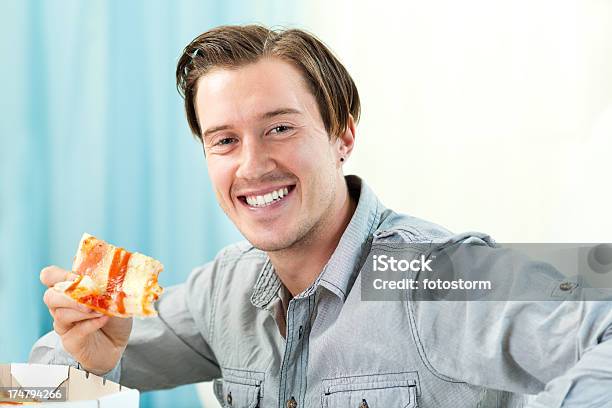 Joven Comiendo Rebanada De Pizza Foto de stock y más banco de imágenes de 20 a 29 años - 20 a 29 años, Adulto, Adulto joven