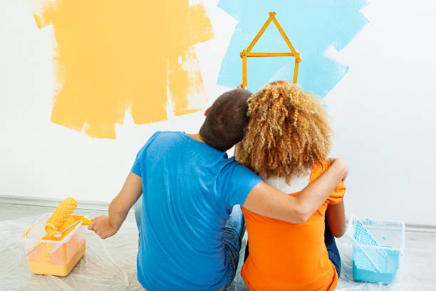 Happy Young Couple Painting Their New Home.