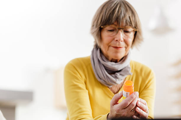 istock Senior woman reading label on medicine 174794956