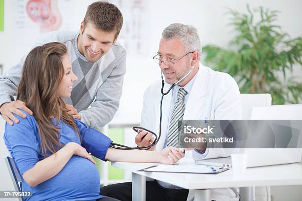 Mulher Grávida Com O Marido No Consultório Médico - Fotografias de stock e mais imagens de Cabelo Grisalho - Cabelo Grisalho, Grávida, Mulheres