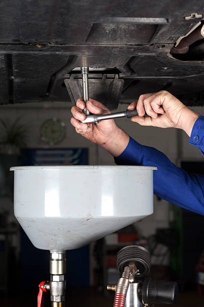 istock Mechanic opens the oil drain plug of a modern car 174796100