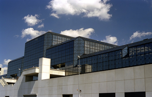 view of modern glass and steel building against cloud sky