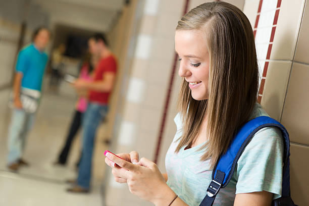 istock Happy high school student texting in a campus hallway 174796281