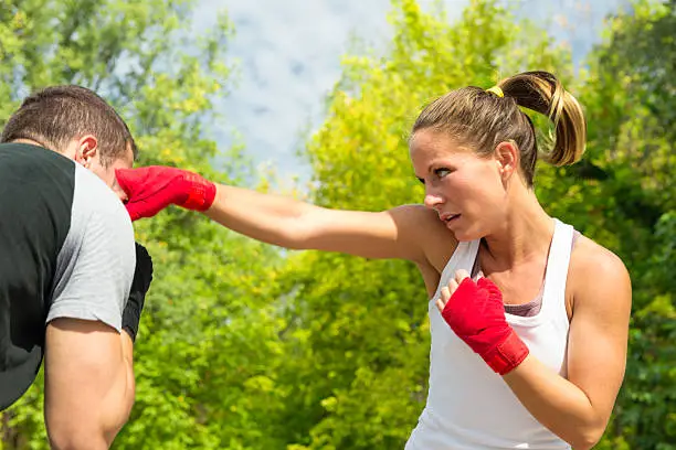 Woman throwing a punch to man on taebo training