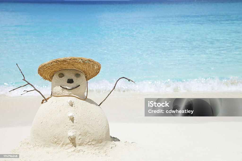 Bałwan śniegowy wykonane z piasku w słomkowy kapelusz na plaży - Zbiór zdjęć royalty-free (Bałwan śniegowy)