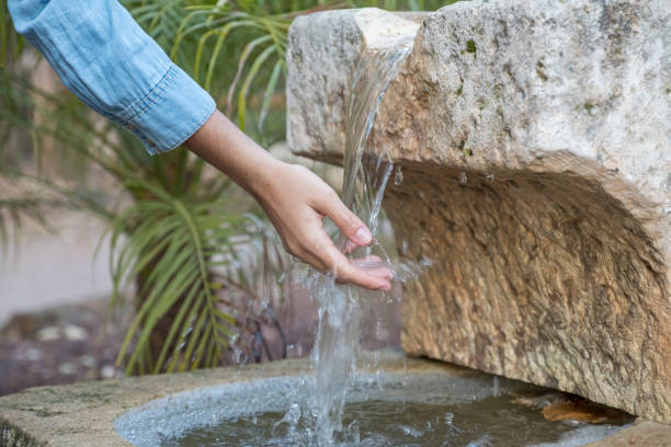 istock Girl's hand caressing fresh water from a fountain or spring 1747965701
