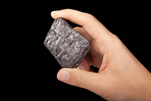 Graphite Hand holding a graphite (natural mineral not a reproduction) mineral sample. lead mine stock pictures, royalty-free photos & images