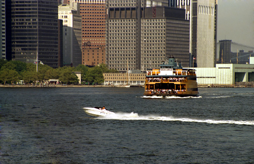 view of speedboat and ferry against skyscrapers in the southern tip of Manhattan