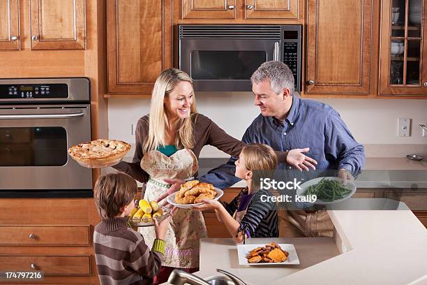 Familia En Cocina Ayudar A Madre Que Sirve La Cena Foto de stock y más banco de imágenes de Familia - Familia, 10-11 años, 30-39 años