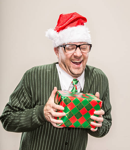 istock Laughing Nerdy Christmas Man holding wrapped holiday gift 174797504