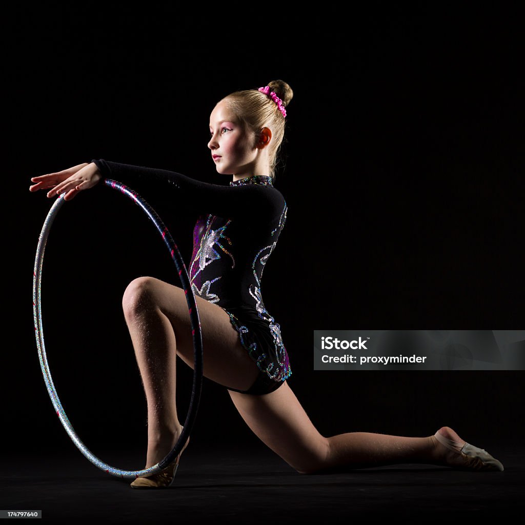 Gimnasta chica con el hula hoop sobre fondo negro - Foto de stock de 10-11 años libre de derechos