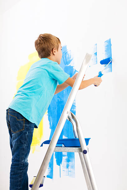 istock Little boy painting the wall 174797805