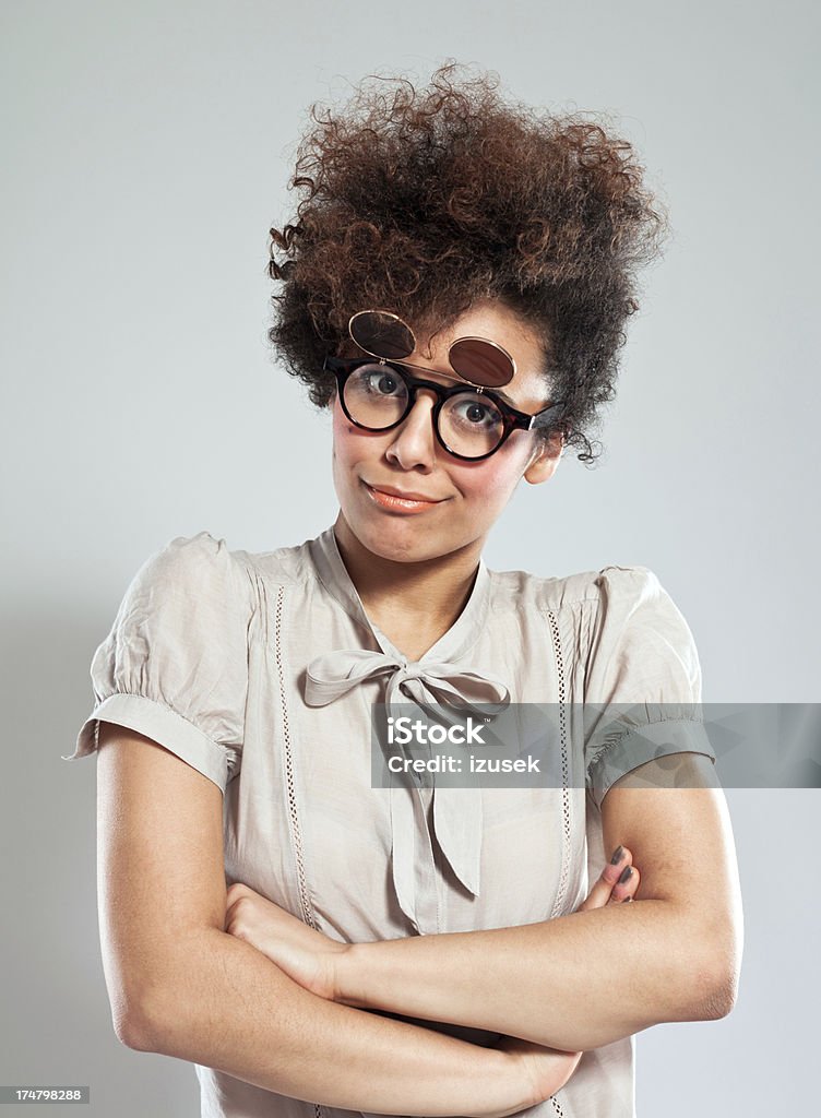 Cute Girl Portrait Portrait of teenaged afro girl wearing funny glasses and looking at camera. Studio shot, grey background. Confidence Stock Photo