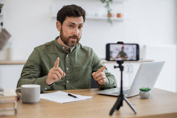 istock Smartphone filming man working on laptop at home office 1747983031