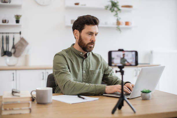 istock Male blogger using smartphone and tripod for live streaming 1747983132