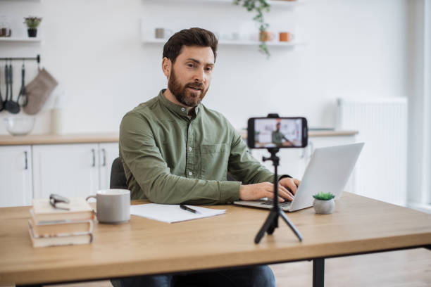 istock Male blogger using smartphone and tripod for live streaming 1747983135