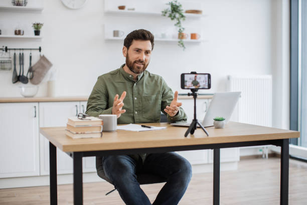 istock Man working on laptop and recording video on smartphone 1747983141