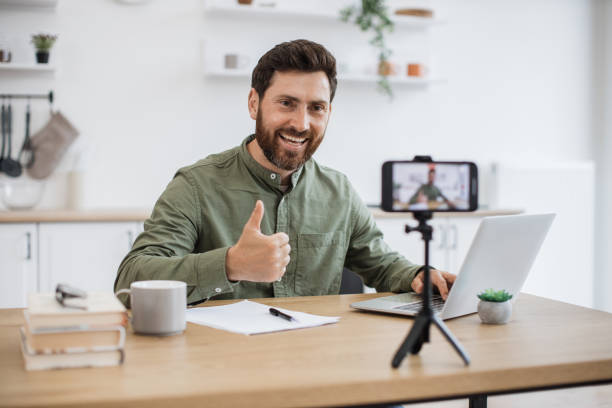 istock Man working on laptop and recording video on smartphone 1747983143