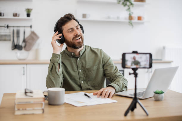 istock Happy male using headphones and making vocal content at home 1747983705