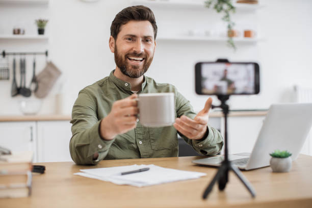 istock Male streamer recording content and holding cup near camera 1747984272