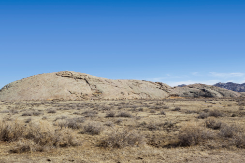 Independence Rock in Wyoming, USA. Independence Rock was a prominent and well-known landmark on the Oregon, Mormon and California emigrant trails. Many emigrants carved their names on the rock.
