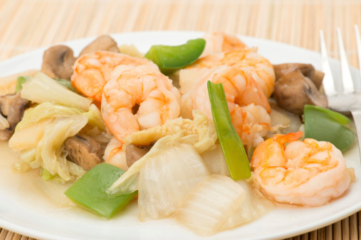 Close-up on a Chinese meal of mixed vegetables and prawns - studio shot with a shallow depth of field.
