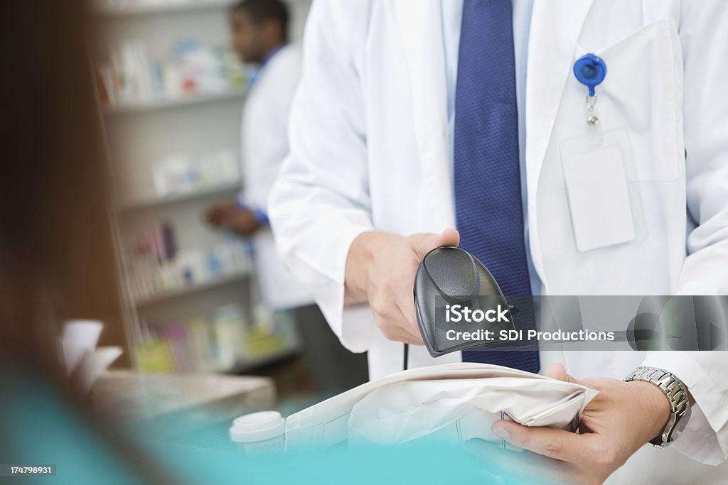 Primo piano di uno scanner come farmacista verifiche di vista del cliente - Foto stock royalty-free di Accudire