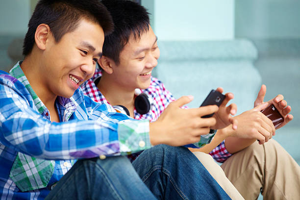 istock teen boy using mobile phone together 174799134