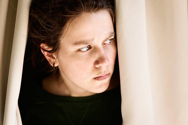 istock What is that? Angry brunette peeps sideways through curtains 174799149
