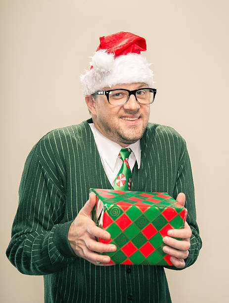 istock Cheesy Nerdy Christmas Man holding wrapped present 174799313