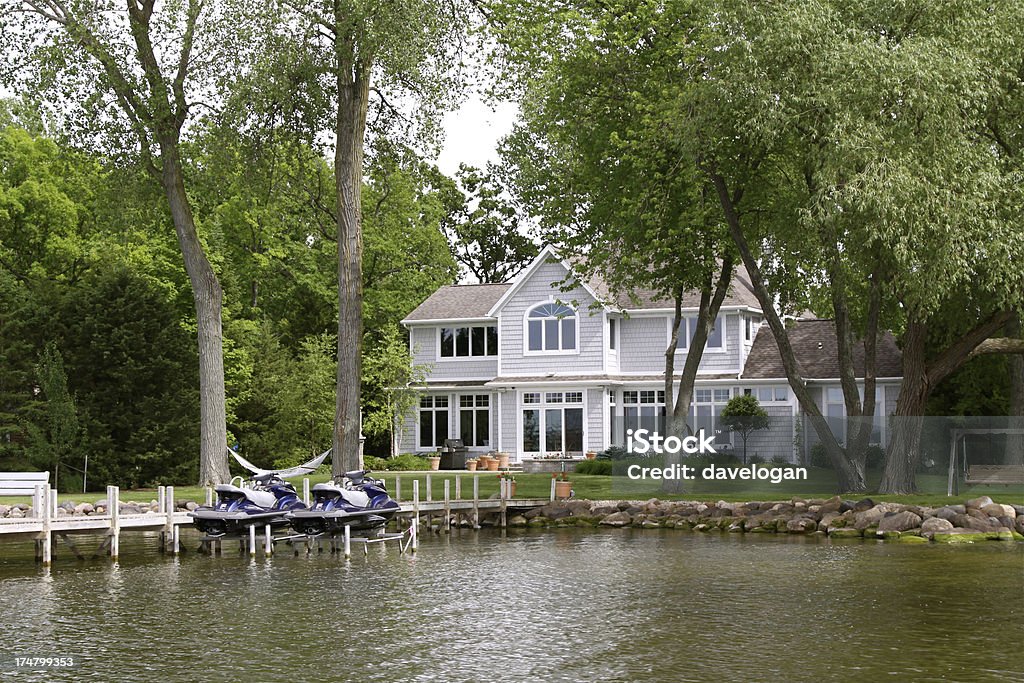 Luxury Home On The Lakefront Luxury home on the lakefront with jet skis Lake Stock Photo