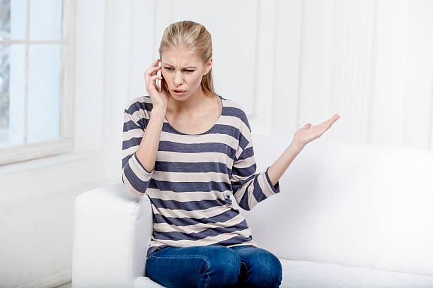 istock young beautiful blond woman sitting on the couch 174799620