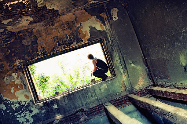 istock Homeless Men Sitting on Window in Burned Building 174799720