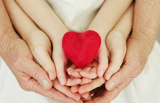 istock Three different ages of hands holding heart 174799750