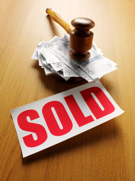 Red Sold Sign and British Pound at a Auction Gavel and mallet on the top of a pile of British twenty pound notes on a wooden table with a red sold sign.Click on the link below to see more of my business and auction images twenty pound note stock pictures, royalty-free photos & images