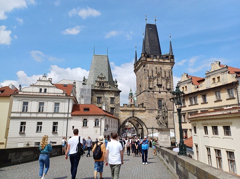 Prague, Czech Republic - June 9, 2023: Tourists walking on Charles bridge and enjoying sightseeing Prague city.