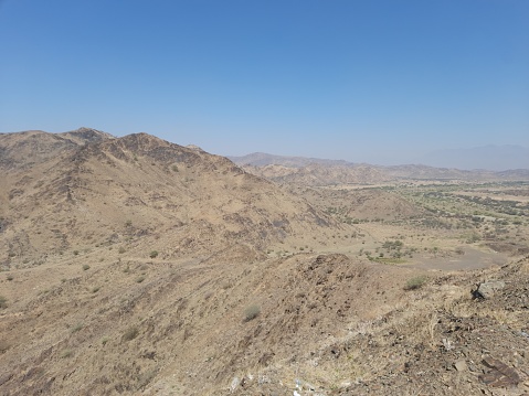 Al-Bahah, mountains, hills, plains and mountain roads in the small city of Al-Hujarah in southern Saudi Arabia on a sunny day and a clear blue sky