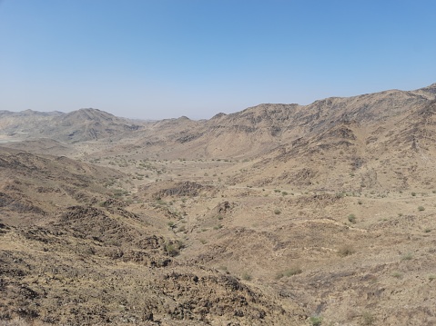 Al-Bahah, mountains, hills, plains and mountain roads in the small city of Al-Hujarah in southern Saudi Arabia on a sunny day and a clear blue sky