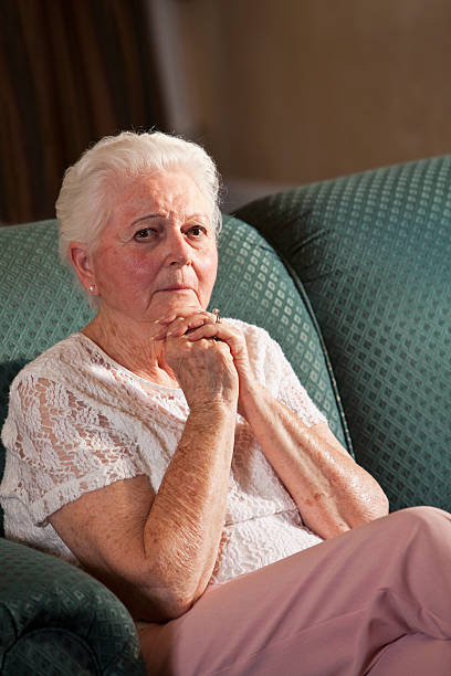 istock Worried senior woman sitting on couch 174801280