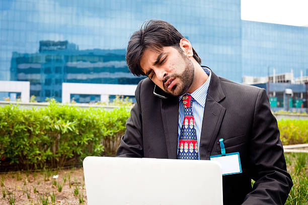 jovem asiática de negócios asiático com laptop e a falar ao telefone - multi tasking asian and indian ethnicities asian ethnicity lifestyles imagens e fotografias de stock