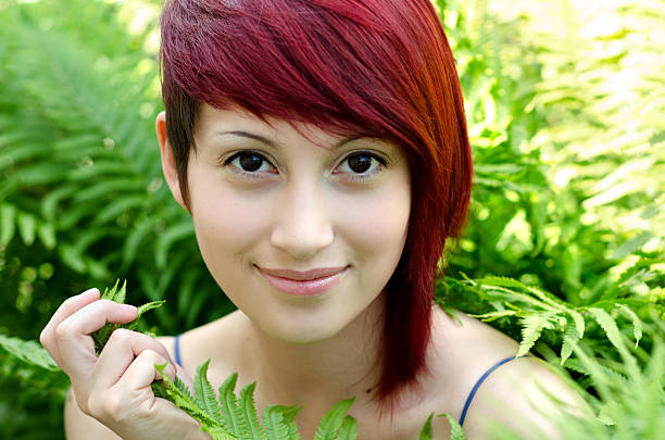 Horizontal outdoor garden shot of young woman against green ferns.