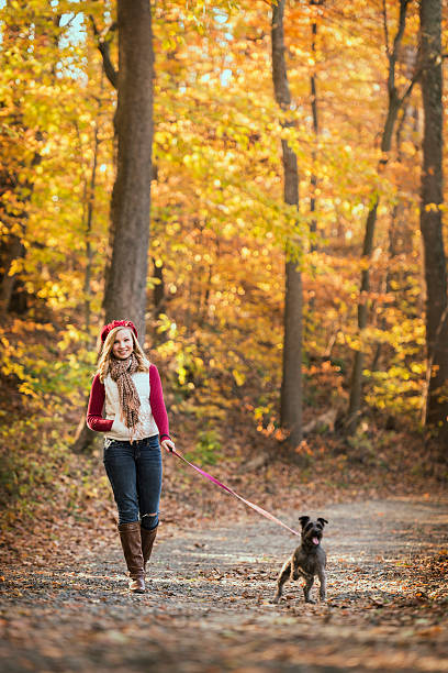 istock Young Woman Walking Her Dog on a Fall Day 174801694