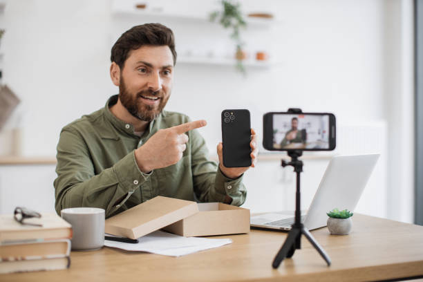 istock Young man recording video while unboxing smartphone indoors 1748017370